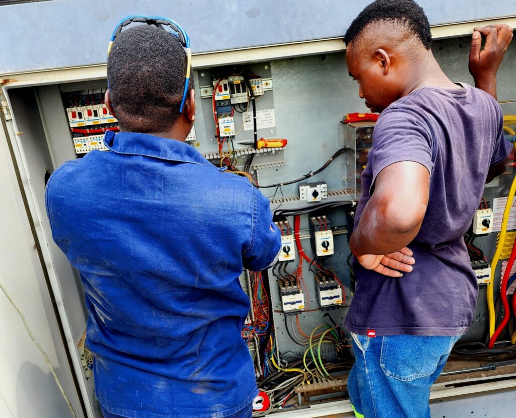 L AND N Group technicians inspecting an electrical control panel