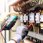 Technician testing an industrial electrical panel